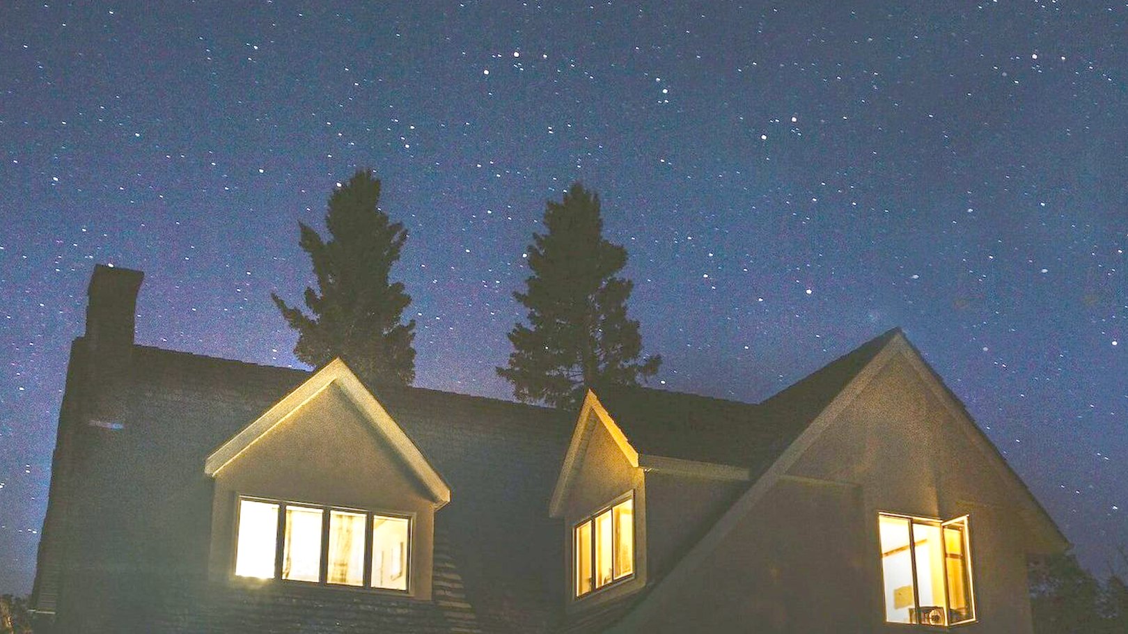A house lit from inside on a clear winter night