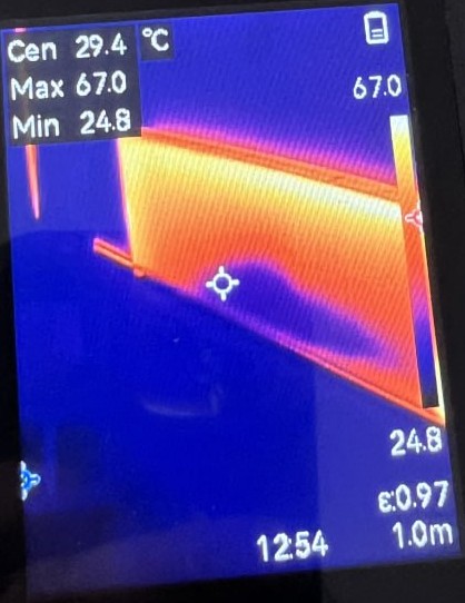Thermal camera frame at 12:54 showing heat only along the top of a radiator, centre 29.4C